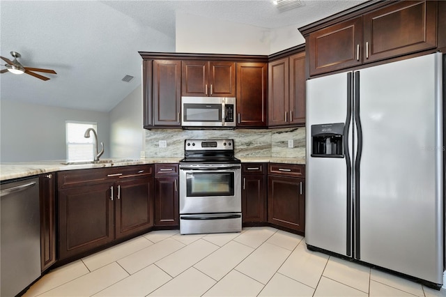 kitchen featuring decorative backsplash, dark brown cabinets, stainless steel appliances, and a sink