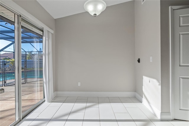 spare room featuring light tile patterned flooring and baseboards