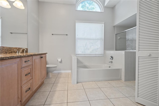 bathroom with vanity, a garden tub, walk in shower, tile patterned floors, and toilet