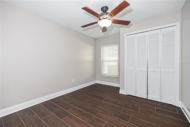 unfurnished bedroom featuring baseboards, wood finish floors, a closet, a textured ceiling, and a ceiling fan