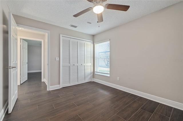 unfurnished bedroom with baseboards, visible vents, wood tiled floor, a closet, and a textured ceiling