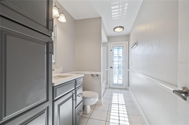 full bath with tile patterned flooring, baseboards, toilet, a bathing tub, and vanity