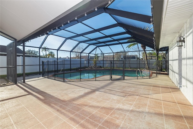 view of swimming pool featuring glass enclosure, a patio, a fenced in pool, and fence