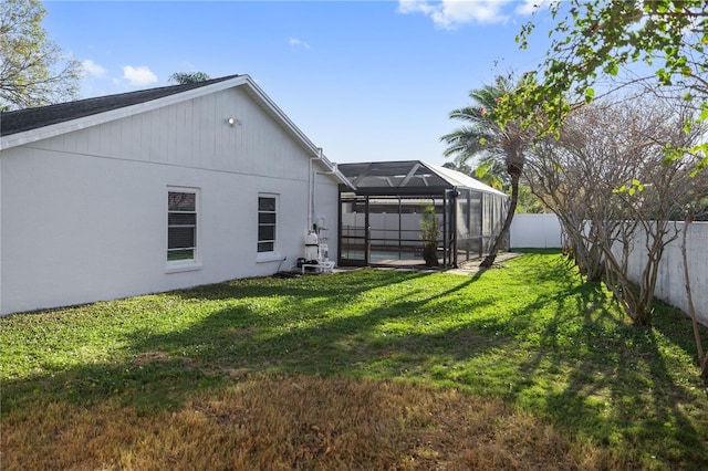 view of yard with glass enclosure and a fenced backyard