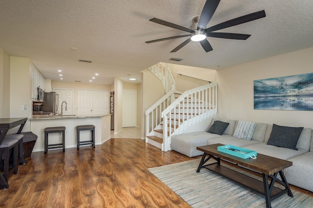 720 Earls Ct, Safety Harbor, FL 34695 - living area with stairs, visible vents, a textured ceiling, and wood finished floors
