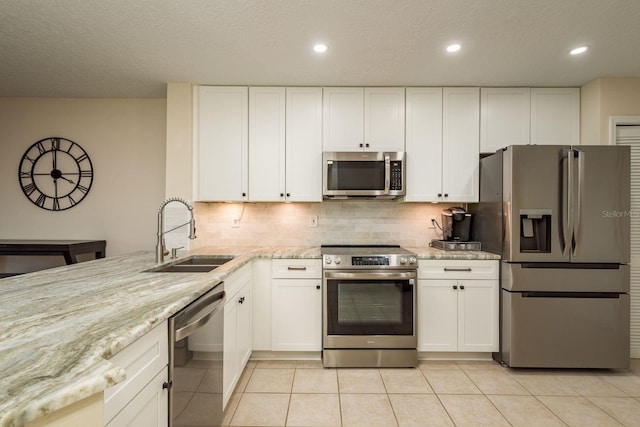 720 Earls Ct, Safety Harbor, FL 34695 - kitchen featuring light stone countertops, appliances with stainless steel finishes, a sink, and light tile patterned flooring