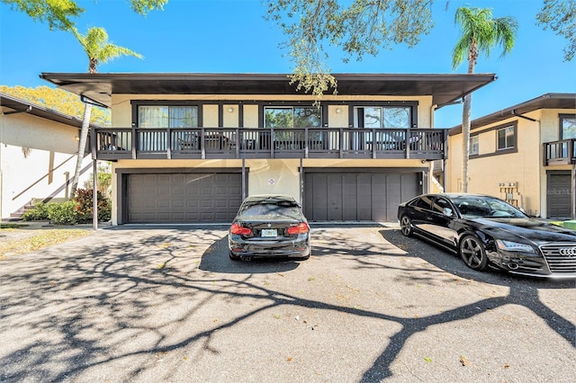 multi unit property featuring an attached garage and stucco siding