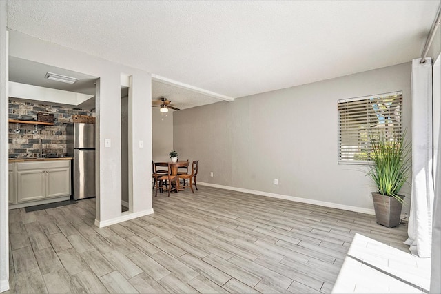 interior space featuring a ceiling fan, baseboards, and wood finish floors