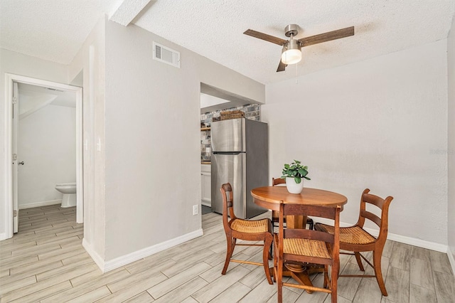 dining room featuring visible vents, baseboards, and wood finish floors