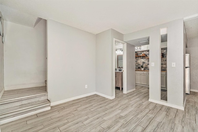 unfurnished living room featuring baseboards and wood tiled floor