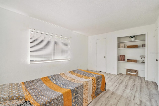 bedroom featuring wood finished floors and a textured ceiling