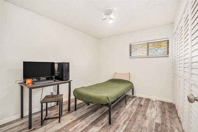 bedroom with wood finished floors and baseboards