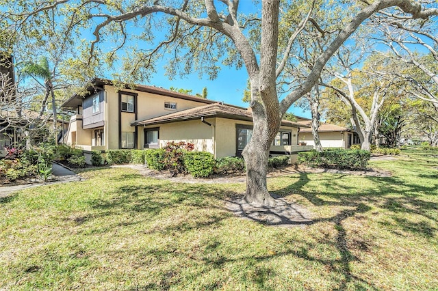 view of front of house with a front lawn, a garage, and stucco siding