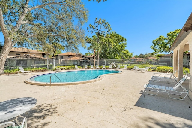 pool featuring a patio, fence, and a residential view