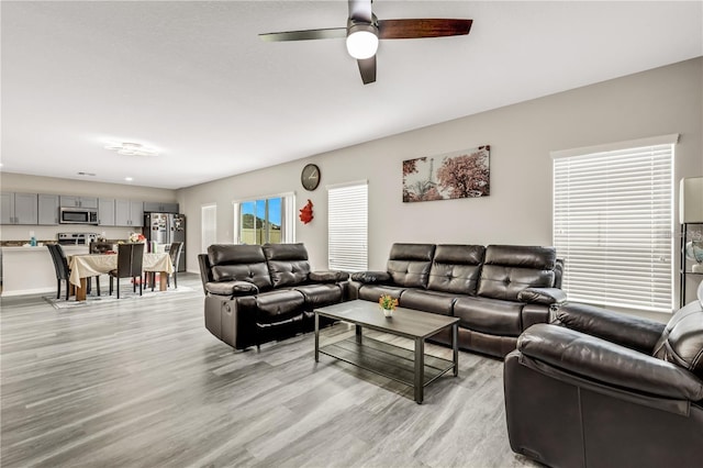 living room with ceiling fan and light wood finished floors