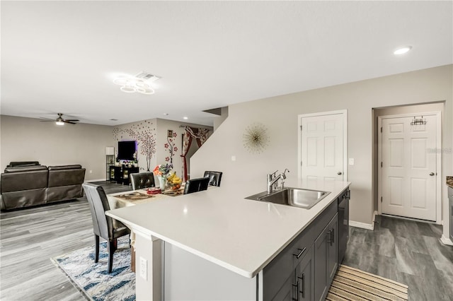 kitchen featuring black dishwasher, light countertops, visible vents, a sink, and wood finished floors