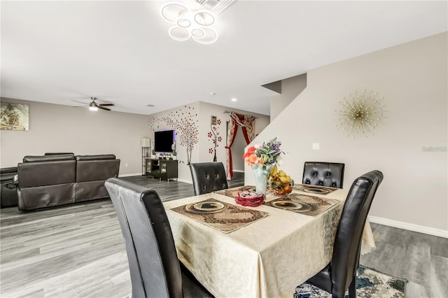 dining space featuring a ceiling fan, stairway, light wood-style flooring, and baseboards