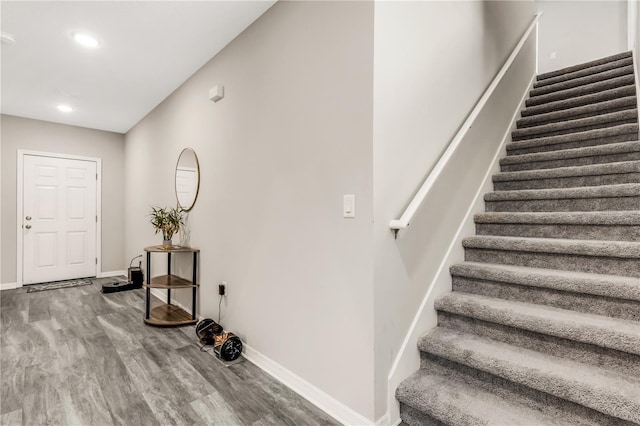 stairs featuring recessed lighting, wood finished floors, and baseboards