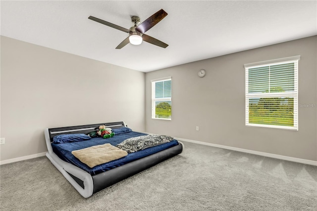 carpeted bedroom with ceiling fan and baseboards