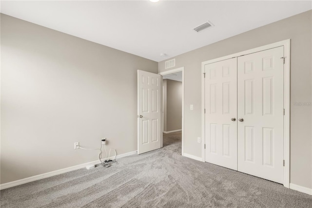 unfurnished bedroom featuring carpet, baseboards, visible vents, and a closet