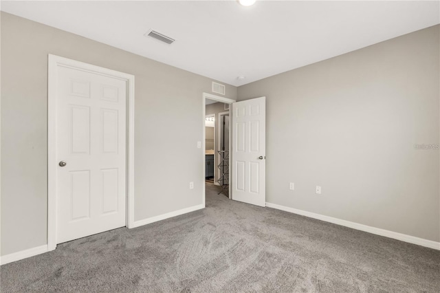 unfurnished bedroom with carpet, visible vents, and baseboards