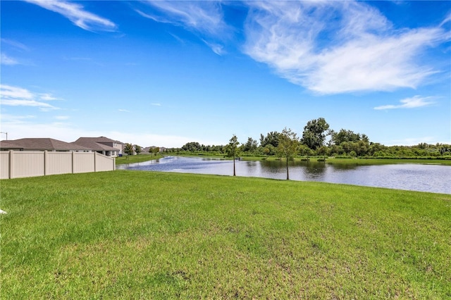 view of yard with a water view and fence