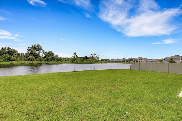 view of yard featuring a water view and fence