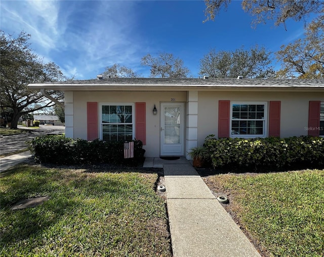 view of front of home featuring a front yard and stucco siding