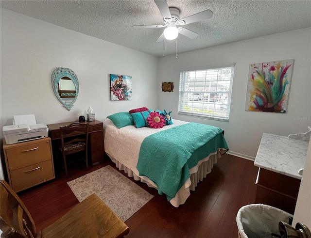 bedroom with ceiling fan, baseboards, dark wood finished floors, and a textured ceiling