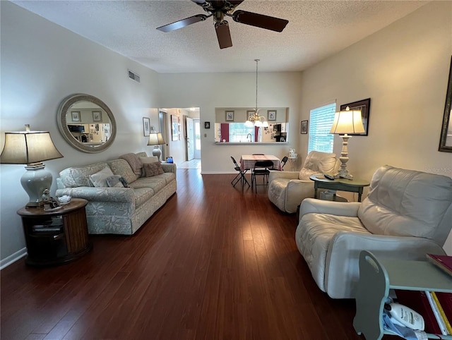 living room with a ceiling fan, wood-type flooring, visible vents, and a textured ceiling