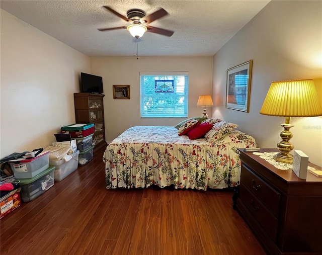 bedroom with dark wood-style floors, a textured ceiling, and a ceiling fan