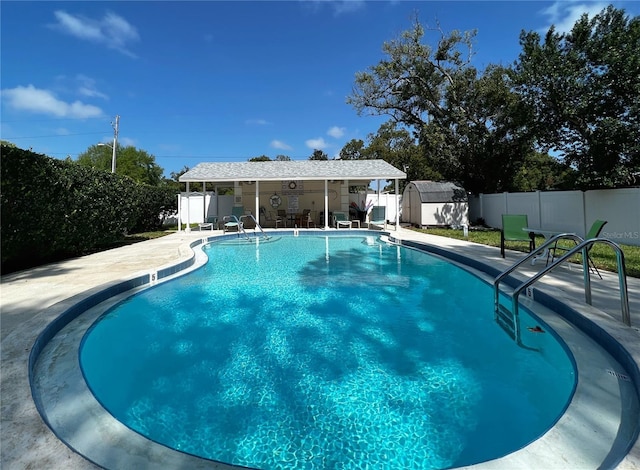 pool featuring a fenced backyard, a patio, and an outdoor structure