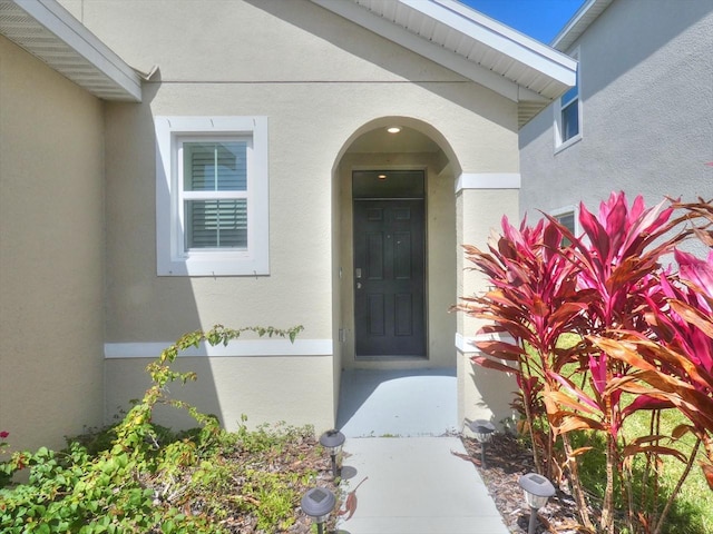 entrance to property featuring stucco siding