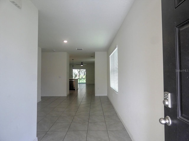 hall with light tile patterned floors and baseboards