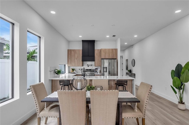 dining area featuring light wood-type flooring, baseboards, and recessed lighting