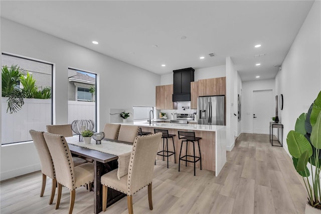 dining room featuring baseboards, light wood finished floors, visible vents, and recessed lighting