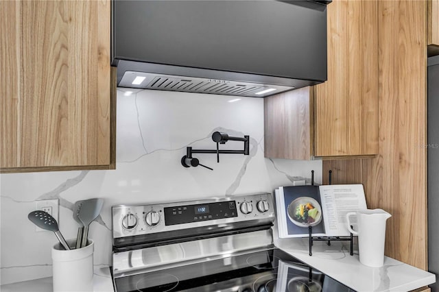 kitchen with light countertops, electric range, brown cabinetry, and ventilation hood