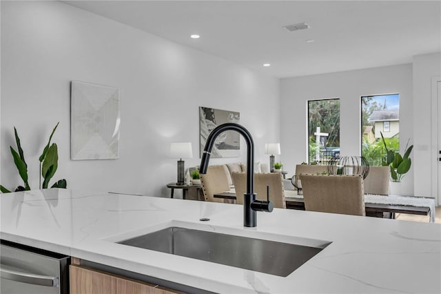 kitchen featuring visible vents, dishwasher, light stone countertops, a sink, and recessed lighting