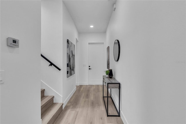 hall with stairway, recessed lighting, light wood-style flooring, and baseboards