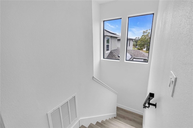 stairs featuring baseboards, visible vents, and wood finished floors