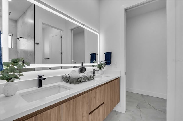 bathroom featuring double vanity, marble finish floor, baseboards, and a sink