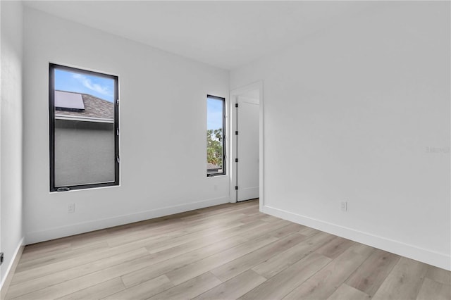 unfurnished room featuring light wood finished floors and baseboards