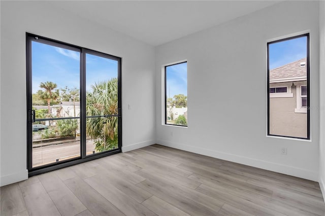 empty room featuring light wood-type flooring and baseboards