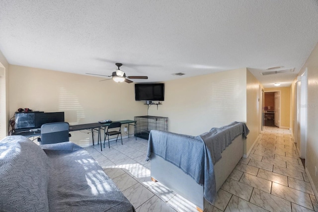 living area with visible vents, baseboards, a ceiling fan, marble finish floor, and a textured ceiling