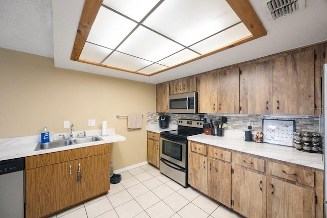 kitchen with stainless steel appliances, light countertops, visible vents, and tasteful backsplash