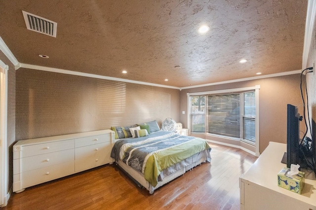 bedroom featuring light wood finished floors, recessed lighting, visible vents, and crown molding