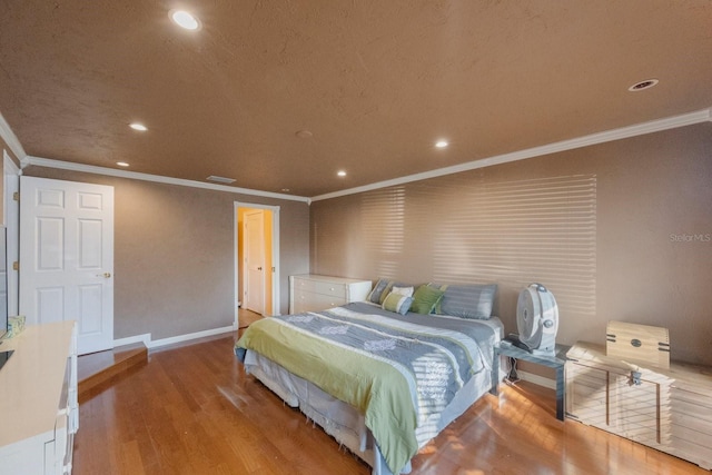 bedroom with visible vents, baseboards, ornamental molding, wood finished floors, and recessed lighting