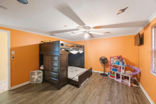 bedroom featuring visible vents, crown molding, a textured ceiling, and wood finished floors