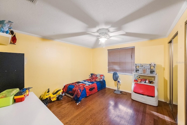 bedroom featuring a textured ceiling, dark wood-style flooring, and crown molding