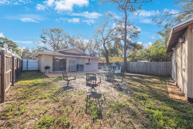 view of yard featuring an outdoor fire pit, a fenced backyard, a patio, and cooling unit